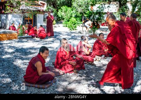 Le dispute dei monaci nel cortile di discussione del Monastero di sera, Lhasa, Tibet. I dibattiti tra i monaci sulle dottrine del buddismo tibetano. Sera Monastero è Foto Stock