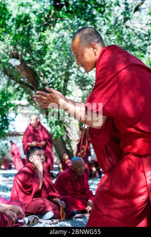 Le dispute dei monaci nel cortile di discussione del Monastero di sera, Lhasa, Tibet. I dibattiti tra i monaci sulle dottrine del buddismo tibetano. Sera Monastero è Foto Stock