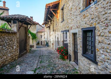 Una stretta strada acciottolata Pérouges, una città medievale murata 30 km a nord-est di Lione, ha assegnato lo status di uno dei più bei villaggi di Francia. Foto Stock