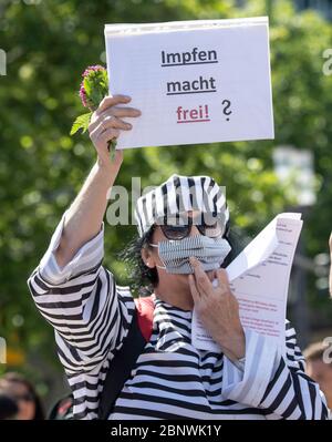 16 maggio 2020, Hessen, Francoforte sul meno: I vestiti di una donna che indossa l'uniforme di un compagno di campo di concentramento che ha partecipato ad un raduno contro le misure di Corona del governo con il segno 'la vaccinazione ti rende liberi? Foto: Boris Roessler/dpa Foto Stock