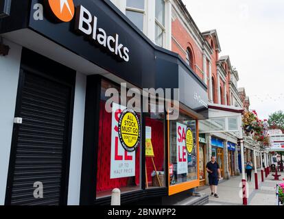 Llandudno, UK: 27 agosto 2019: Un negozio di abbigliamento e attrezzature per esterni neri con banner per finestre che pubblicizzano una vendita in cui tutte le scorte devono andare. Il stor Foto Stock