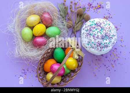 Uova di Pasqua multicolore in un cestino e vista del nido dall'alto Foto Stock