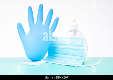 Guanto monouso in nitrile gonfiato con maschera medica protettiva e flacone in plastica di gel disinfettante antibatterico per le mani: Protezione anti-diffusione dei virus Foto Stock