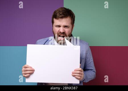 L'uomo dispiaciuto tiene una lavagna vuota con spazio per la copia e grida ad alta voce. Sconti stagionali, pubblicità. Foto Stock