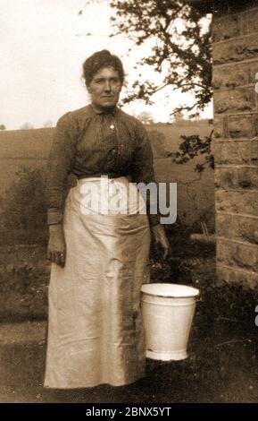 Ritratto fotografico di una milkmaid dello Yorkshire del Nord con il suo secchio e grembiule (pinny) circa 1900 Foto Stock