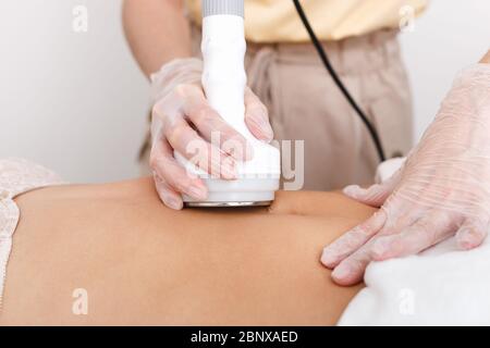 Il cosmetologo fa cavitazione dell'addome del modello, correzione hardware della figura, la distruzione di peso in eccesso, o cellule grasse. STU Foto Stock