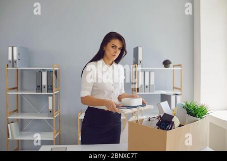 La disoccupazione ha licenziato una donna d'affari sconvolta con una scatola di cartone lascia il posto di lavoro dall'ufficio dell'azienda. Licenziamento. Pressione dell'errore di sollecitazione Foto Stock