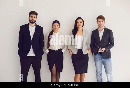 Gruppo di giovani uomini d'affari squadra in piedi lavoro di squadra sullo sfondo. Concetto meeting businessmen business donne analytics startup idea strategia te Foto Stock