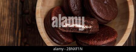 Alcuni dolci torta Choco su sfondo di legno tra caffè sparsi bean.Sweet banner. Foto Stock