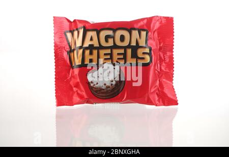Una singola barretta di cioccolato Wagon Wheels nel suo pacchetto isolato su uno sfondo bianco con un riflesso. Foto Stock