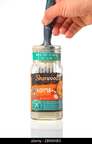 Una pentola di salsa di cottura di Sharwoods usata come contenitore del pulitore della spazzola di vernice come parte di uso di riciclaggio dei prodotti e del vetro. Isolato su un fondo bianco. Foto Stock