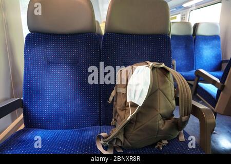 Uno zaino in un carrello vuoto con una maschera N95 attaccata ad esso in modo che possa essere utilizzato se necessario. Le maschere facciali non sono obbligatorie in Svizzera Foto Stock