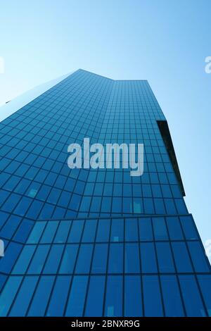 una facciata di un alto e moderno edificio aziendale costituito da rettangoli di vetro ombreggiato Foto Stock