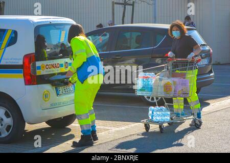 Italia, 04/08/20: Due paramedici volontari italiani in uniforme indossando maschera protettiva del coronavirus fanno generi alimentari per gli anziani e i malati. Pandemia quotidiana Foto Stock