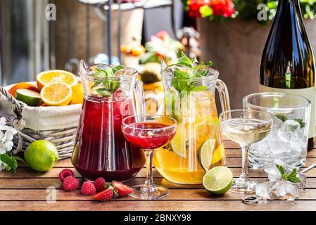 Bevanda fresca estiva con agrumi, bacche e ghiaccio. Foglie di arancio, lime, fragola, menta Foto Stock
