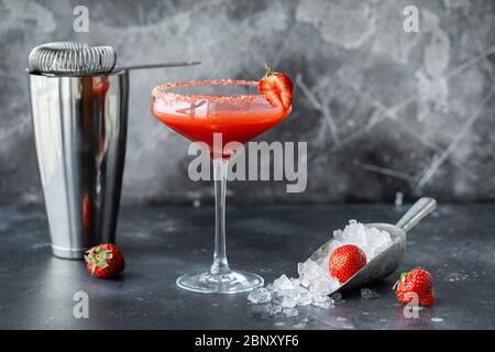 Cocktail di fragole con ghiaccio. Attrezzi da bar per la preparazione di bevande e agitatore Foto Stock