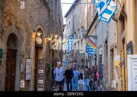 Persone che camminano per le strade di Volterra in Toscana, Italia Foto Stock