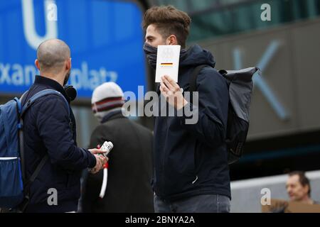 Berlino, Germania. 16 maggio 2020. Allo stesso tempo, quattro raduni si tennero su Alexanderplatz, che furono cordonati da ufficiali di polizia e da un nastro rosso e bianco. Sulla piazza, persone con bandiere e un'auto altoparlante dimostrarono contro le teorie della cospirazione e per i diritti dei rifugiati. A pochi metri di distanza, persone con musica forte dimostrarono contro le regole della corona e la vaccinazione. (Foto di Simone Kuhlmey/Pacific Press) Credit: Pacific Press Agency/Alamy Live News Foto Stock