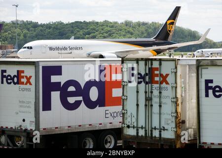 I rimorchi FedEx Express Truck sono visti di fronte a un aeromobile UPS Airlines United Parcel Service a Middletown, Pennsylvania, il 4 maggio 2020. Foto Stock