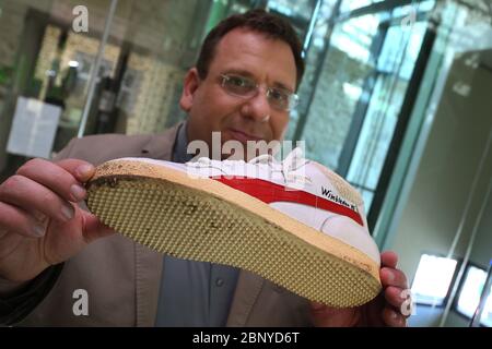 Iphofen, Germania. 8 maggio 2020. Markus Mergenthaler, direttore del museo di Knauf, mostra una scarpa sportiva indossata dal tre volte campione di Wimbledon Boris Becker alla sua prima vittoria nel 1985. 80 mostre di scarpe speciali saranno presentate nella mostra speciale 'Shoe Stories' nel museo dal 19 maggio. Credit: Karl-Josef Hildenbrand/dpa/Alamy Live News Foto Stock