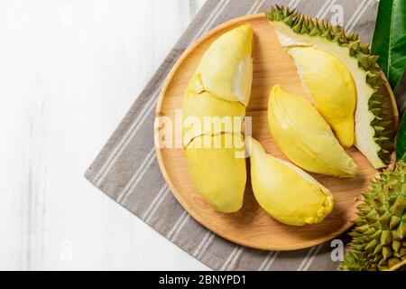 Vista dall'alto del fresco durian (monthong) su un piatto di legno e sfondo di legno bianco, re di frutta dalla Thailandia nella stagione estiva Foto Stock