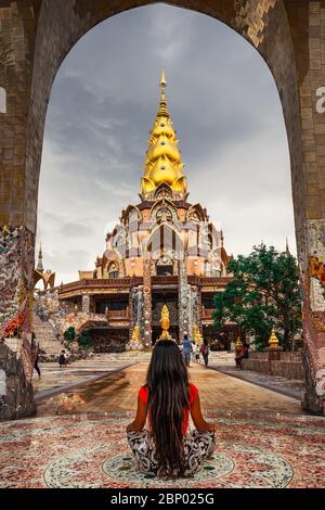 Ragazza viaggiatore meditare in lotus posa in un tempio buddista Thailandia sullo sfondo bella natura. Turismo bella destinazione luogo Asia Foto Stock