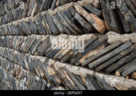 Una recinzione costruita da file di roccia ardesia stratificata con cemento è usato per creare una barriera efficace a Hongcun, Cina. Foto Stock