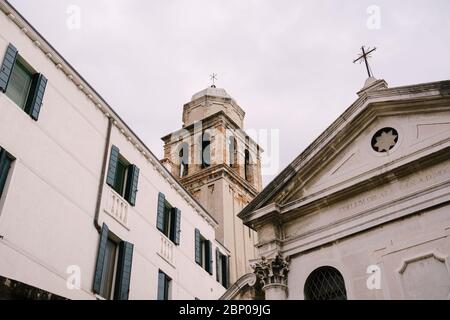 Venezia, Italia - 04 ottobre 2019: Primo piano della facciata di un edificio, sulle strade di Venezia. Il campanile in mattoni sovrasta Foto Stock