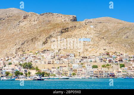 Case a forma di cubo salgono sulle colline sopra la città di Pothia, sull'isola Dodecanese di Kalymnos, Grecia Foto Stock