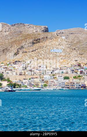 Case a forma di cubo salgono sulle colline sopra la città di Pothia, sull'isola Dodecanese di Kalymnos, Grecia Foto Stock