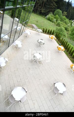 tavoli e sedie da ristorante all'aperto, seduti in un ristorante moderno in una giornata di sole primavera durante la pandemia scoppio blocco del coronavirus Foto Stock