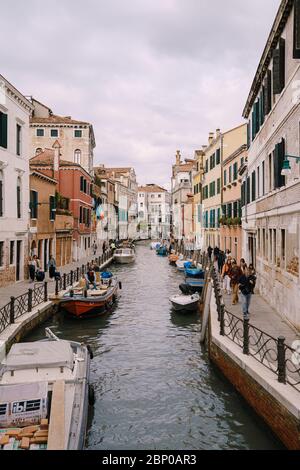 Venezia, Italia - 04 ottobre 2019: Vista classica dello stretto canale veneziano. Edifici colorati si ergono di fronte l'uno all'altro, gondoliere cavalcare turisti Foto Stock