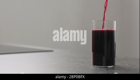 succo di mirtillo versare nel bicchiere di highball sul piano cucina Foto Stock