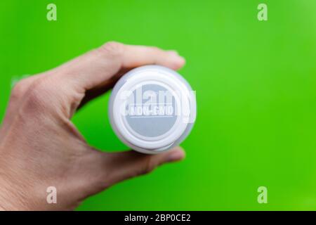 Bottiglie bianche di integratori vitaminici con tappo non ogm su sfondo verde chiaro Foto Stock