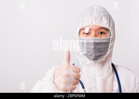 Donna asiatica medico o infermiere in uniforme PPE e guanti indossare maschera protettiva in laboratorio tenendo mostrare pollice per il buon segno, lui Foto Stock