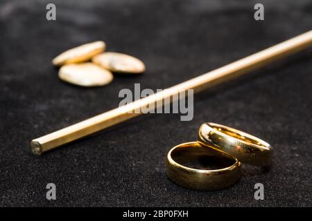 Concetto del processo in cui un grumo d'oro viene trasformato in un paio di anelli di nozze Foto Stock