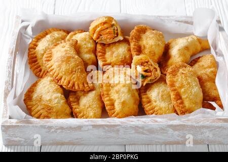 Deliziose Empanadas di pollo fritte RedHot Buffalo in un rustico vassoio di legno, vista orizzontale dall'alto Foto Stock