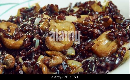 Risotto di riso nero con funghi e cipolla caramellata Foto Stock