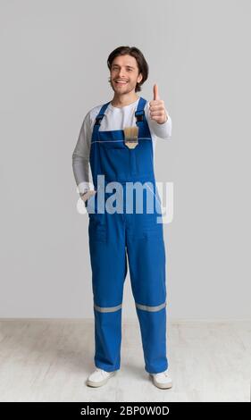 Professionista Pittore di casa in lavoro uniforme gesturing Thumb Up Foto Stock