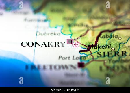 Profondità di campo poco profonda focalizzazione sulla mappa geografica posizione della città di Conakry nel continente Guinea Africa sull'atlante Foto Stock
