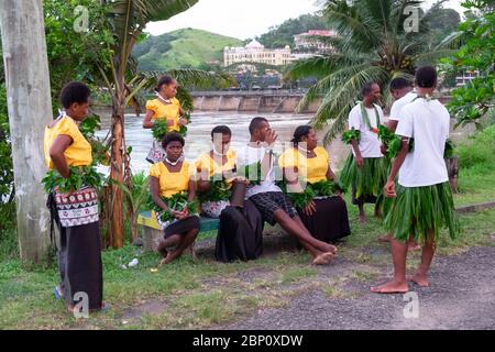 Uomini e donne vestiti per una cerimonia tradizionale aspettano vicino al fiume a Sigatoka (Singatoka), Figi Foto Stock