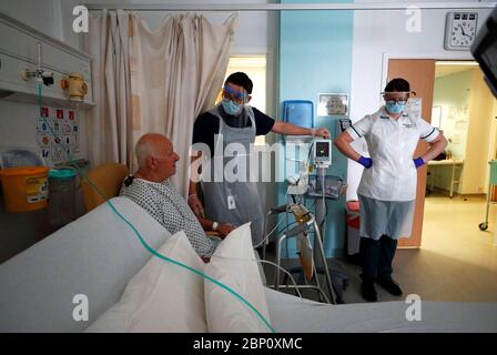 I terapisti professionali Jason Smith (centro) e Grace Rowan (destra) valutano il paziente di coronavirus in guarigione Peter Dunn su Ward C22 presso il Royal Blackburn Teaching Hospital di East Lancashire durante lo scoppio della malattia del coronavirus. Foto Stock