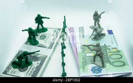 Miniatura plastica figura di soldati in cima a due fasci, uno fatto di dollari di bollette e l'altro di euro con un fossato di plastica nel mezzo Foto Stock