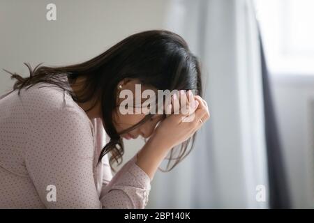 La donna africana copre il viso con le mani sembra disperata e infelice Foto Stock