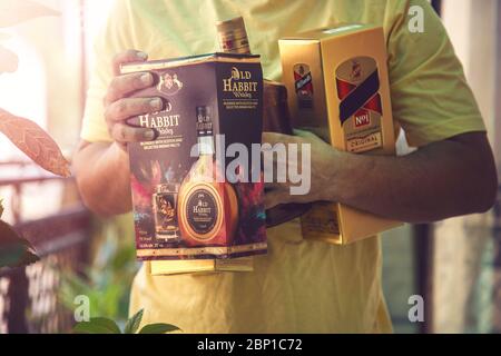 New Delhi, India - 16 MAGGIO 2020 : Unidentified Closeup di mano dell'uomo che tiene bottiglia del liquore di whisky durante il blocco di Covid-19 mentre lascia dopo l'acquisto Foto Stock