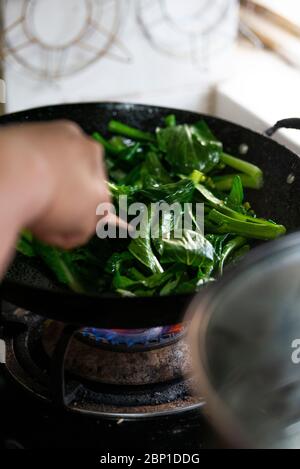 Verdure fritte in padella nella cucina cinese a conduzione familiare Foto Stock