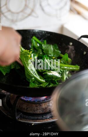 Verdure fritte in padella nella cucina cinese a conduzione familiare Foto Stock