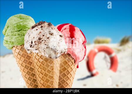 Coni gelato in primo piano con diversi sapori sullo sfondo della spiaggia Foto Stock