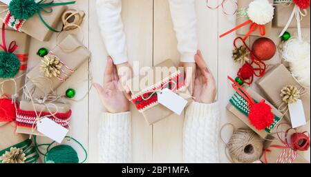 Regali di Natale su sfondo bianco. La mamma dà al bambino un regalo Foto Stock