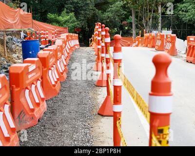 Medellin, Colombia, ottobre 20 2019: Barriere di costruzione arancione su una strada lavori con sentiero pedonale Foto Stock